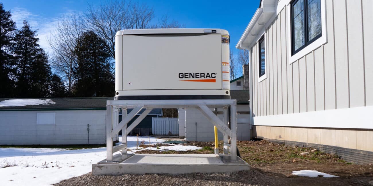 Generac generator on an aluminum stand in a big backyard of a beach house