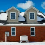 a house with snow on the roof and Generac standby backup home generator installed with a transfer switch in Shanty Bay Ontario by Platinum number one Generac dealer in Ontario